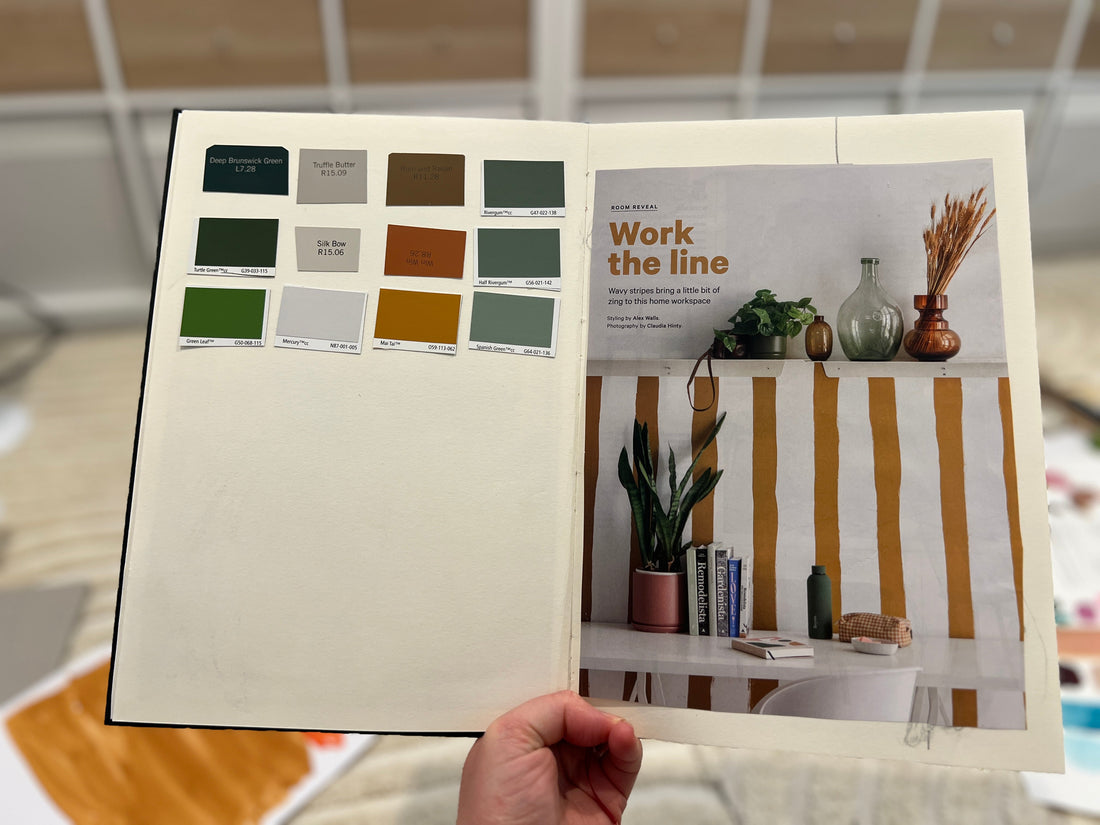 Open sketchbook with a magazine clipping on one page and a hand-painted color palette from that image on the facing page